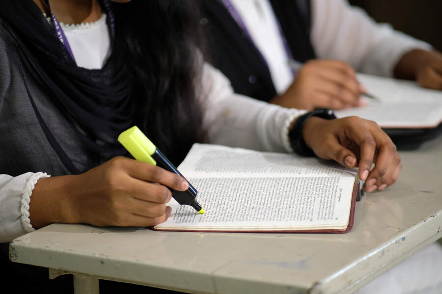 A student highlighting her Bible during study